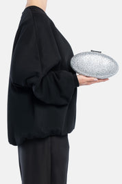 Clutch indare argento, portata a mano dalla modella. TWENTYFOURHAITCH.
