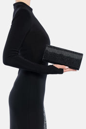 Clutch nera french 75, portata a mano dalla modella. TWENTYFOURHAITCH.