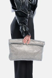 Maxi pouch dunham argento, portata a mano dalla modella. TWENTYFOURHAITCH.