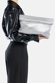 Maxi pouch dunham metal argento, portata a mano dalla modella. TWENTYFOURHAITCH.