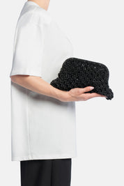 Pochette kaira nera, portata a mano dalla modella. TWENTYFOURHAITCH.