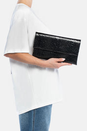 Pochette nireya nera, portata a mano dalla modella. TWENTYFOURHAITCH.